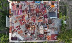 Evinin çatısında dokuma halı ve kilim sergiliyor
