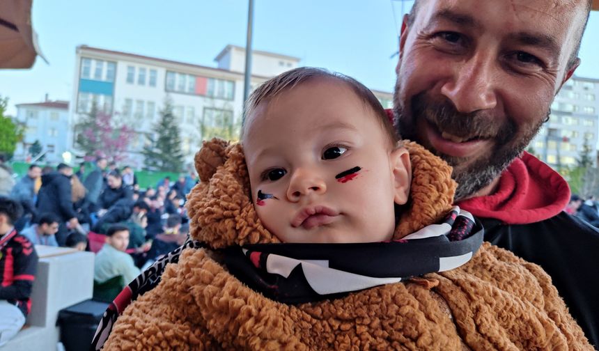 Babasının Kucağında, Yüzünde Siyah-Kırmızı